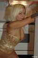Natural busty Martina posing in a golden corsage, black leggins, pantyhose and heels in the kitchen 9