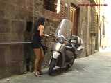 016141 Eve Tries To Hide Beside A Parked Motorcycle As She Pees In The Street 7