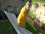 Watch Chloe enjoying the warm Sun in her yellow shiny nylon Rainsuit  5