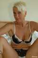 Short haired blonde MILF Claudia posing on bed 5